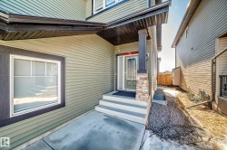 The property features a welcoming entrance with steps leading to the front door, a column accented with stone detailing, and a prominent window - 