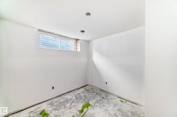 This room features white walls, a window with blinds, and recessed lighting in the ceiling - 