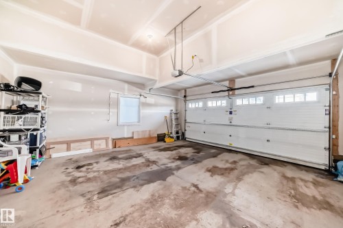 The property features an attached garage with a white sectional door, including window inserts, and an automatic garage door opener - 22407 99 Avenue, Edmonton, AB - Indoor Photo Showing Garage