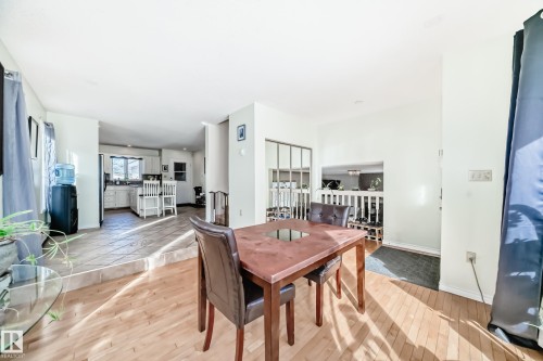 The property features an open layout with light hardwood flooring in the foreground and tile flooring in the kitchen area - 16232 100 Street, Edmonton, AB - Indoor Photo Showing Dining Room