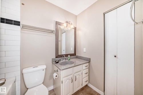 This bathroom features a vanity with a granite countertop, a mirror with an ornate frame, and an integrated sink - 16232 100 Street, Edmonton, AB - Indoor Photo Showing Bathroom