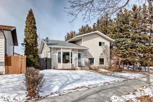 The property features a light-colored exterior, a grey shingled roof, and a bay window - 16232 100 Street, Edmonton, AB - Outdoor