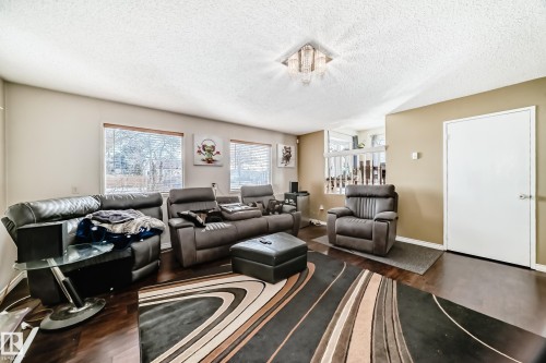 Living area featuring dark wood flooring, two large windows with blinds, and a built-in light fixture - 16232 100 Street, Edmonton, AB - Indoor Photo Showing Living Room