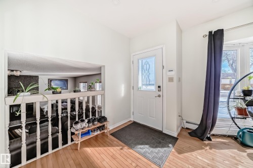 Entryway with hardwood floors, a white front door with decorative glass, and a large bay window - 16232 100 Street, Edmonton, AB - Indoor Photo Showing Other Room