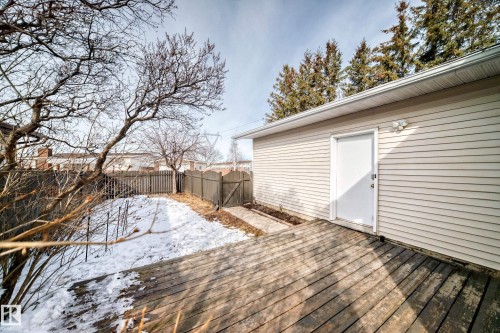 The property features a wood deck, a light-colored exterior wall, and a white exterior door - 16232 100 Street, Edmonton, AB - Outdoor