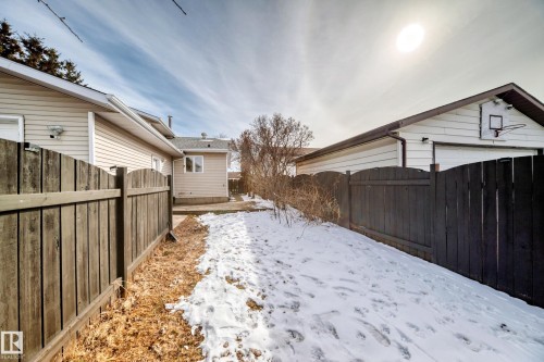 The property features a large yard with a wooden fence and a detached garage with a basketball hoop - 16232 100 Street, Edmonton, AB - Outdoor With Exterior