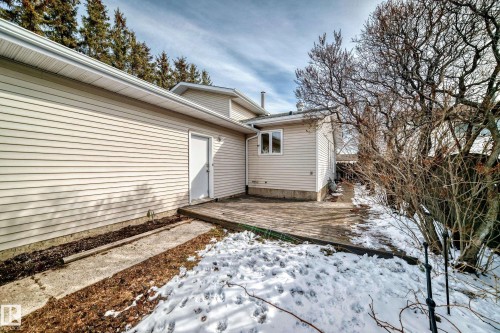 The property features an outdoor patio deck, a white exterior door, and light-colored siding - 16232 100 Street, Edmonton, AB - Outdoor
