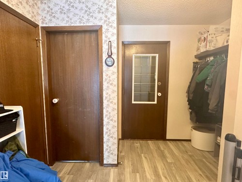 The property features wood-look flooring and a door with a window insert - 9915 95 Street, Westlock, AB - Indoor Photo Showing Other Room