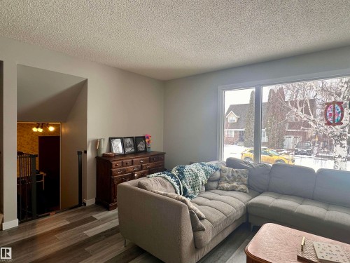 Living area featuring a large window, a classic wooden chest of drawers, and durable flooring - 9915 95 Street, Westlock, AB - Indoor Photo Showing Living Room