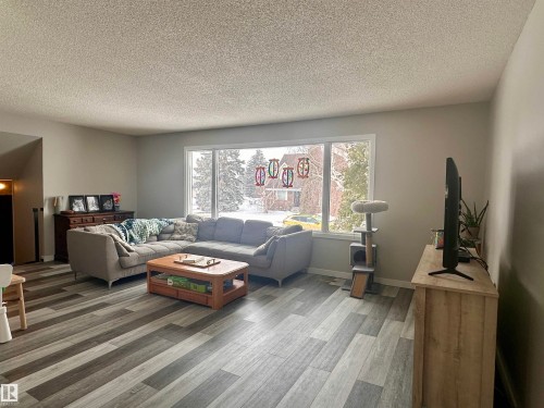 The living area features a large window, providing natural light and views of the exterior - 9915 95 Street, Westlock, AB - Indoor Photo Showing Living Room
