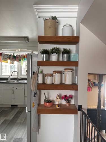Kitchen area featuring white cabinetry, a double basin sink, and a window with natural light - 9915 95 Street, Westlock, AB - Indoor