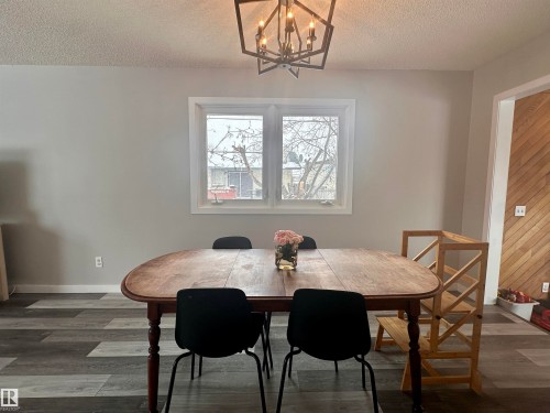 Dining area featuring light gray walls, a window with white trim, and patterned flooring - 9915 95 Street, Westlock, AB - Indoor Photo Showing Dining Room
