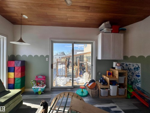 Interior space featuring hardwood ceilings, light-colored walls with a decorative green border, and gray flooring - 9915 95 Street, Westlock, AB - Indoor
