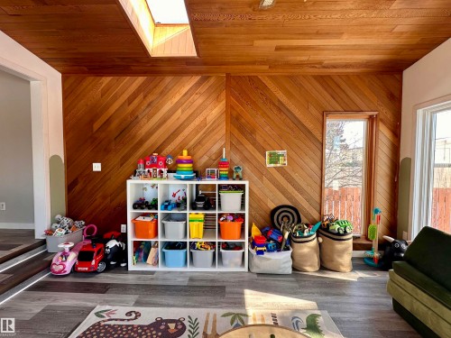 This room features wood plank walls with a diagonal pattern, a wood plank ceiling, and a skylight providing natural light - 9915 95 Street, Westlock, AB - Indoor Photo Showing Other Room