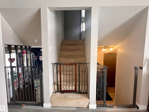 Carpeted staircase with access to additional levels of the property - 9915 95 Street, Westlock, AB - Indoor Photo Showing Other Room