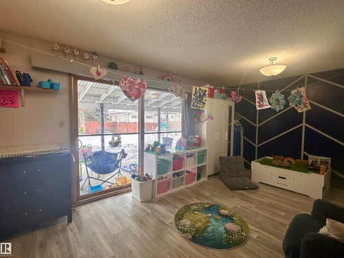 This inviting room features light-toned flooring and a sliding glass door providing access to the outdoors - 9915 95 Street, Westlock, AB - Indoor