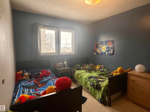 The room features two windows and a ceiling-mounted light fixture - 9915 95 Street, Westlock, AB - Indoor Photo Showing Bedroom
