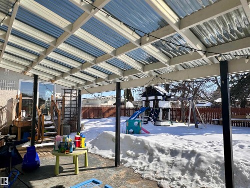 The property features a covered patio area with a clear, corrugated roof, providing shelter while allowing light to pass through - 9915 95 Street, Westlock, AB - 