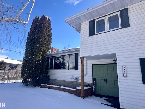 The property features white siding, dark window shutters, and a green double entry door - 9915 95 Street, Westlock, AB - Outdoor With Exterior