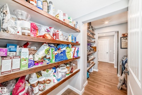 The property features a spacious pantry with extensive wooden shelving, providing ample storage - 6303 2 Avenue, Edmonton, AB - Indoor