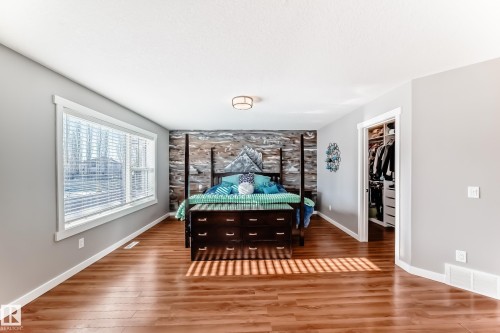 This property features hardwood floors, a large window providing natural light, and a closet with custom storage solutions - 6303 2 Avenue, Edmonton, AB - Indoor Photo Showing Other Room