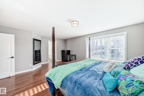 This room features hardwood flooring, light grey walls, and a large window with blinds - 6303 2 Avenue, Edmonton, AB - Indoor Photo Showing Bedroom