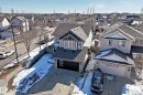 The property features a two-car garage, a paved driveway, and an exterior of light-colored siding and stone accents - 6303 2 Avenue, Edmonton, AB  - Outdoor 