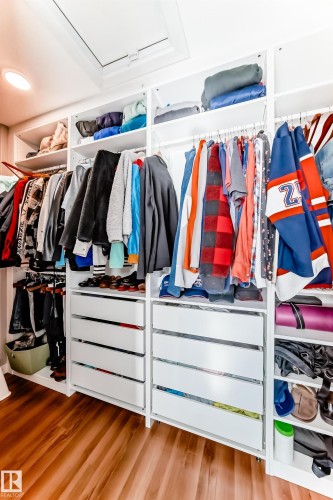 Custom closet system featuring white shelving, drawers with silver hardware, and hardwood floors - 6303 2 Avenue, Edmonton, AB - Indoor With Storage