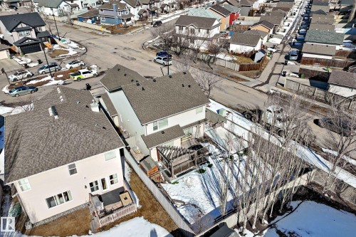 Aerial view showcasing the property's exterior, including a deck with a pergola, a lawn area, and surrounding mature trees - 6303 2 Avenue, Edmonton, AB - Outdoor