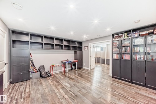 The room features wood-style flooring, recessed lighting, and extensive built-in shelving and cabinetry - 6303 2 Avenue, Edmonton, AB - Indoor