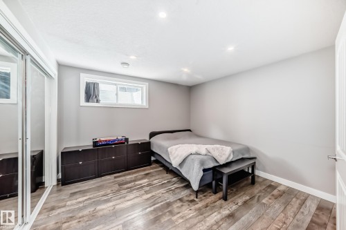 This room features wood-look flooring, light grey walls, and recessed lighting - 6303 2 Avenue, Edmonton, AB - Indoor