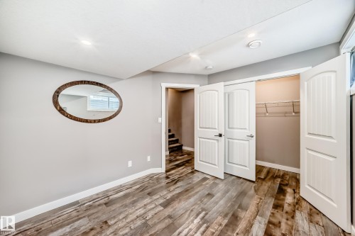 This room features wood-look flooring, light gray walls, and white trim - 6303 2 Avenue, Edmonton, AB - Indoor Photo Showing Other Room