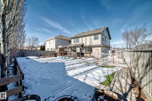 The property features a fenced yard with a combination of wooden and panel fencing, a paved walkway, and a rear deck - 6303 2 Avenue, Edmonton, AB - Outdoor
