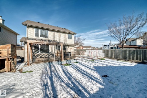 The property features a spacious backyard with a wooden fence and a pergola-covered patio - 6303 2 Avenue, Edmonton, AB - Outdoor
