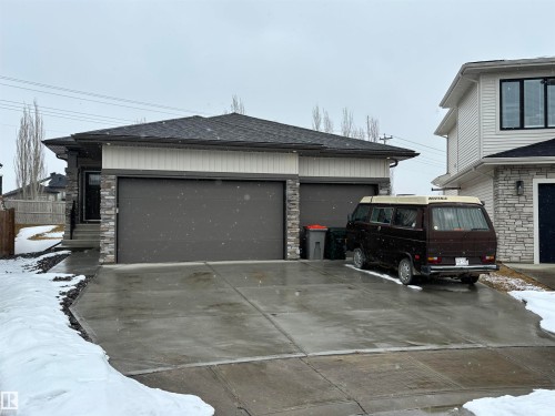 The property features a dark gray shingled roof, a two-door garage with dark gray doors, and a concrete driveway - 137 Graybriar Drive, Stony Plain, AB - Outdoor