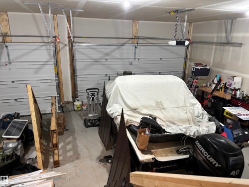 The property includes a spacious garage with two overhead doors and an automatic opener - 137 Graybriar Drive, Stony Plain, AB - Indoor Photo Showing Garage