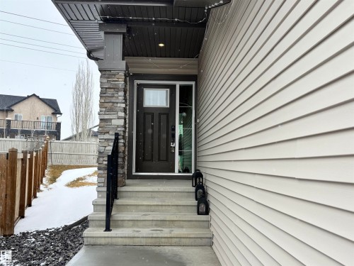 The property features a dark brown front door with a window, complemented by stone cladding on the entry pillar - 137 Graybriar Drive, Stony Plain, AB - Outdoor With Exterior