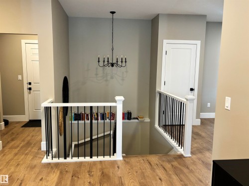 Entryway featuring hardwood flooring, white doors, and a black chandelier - 137 Graybriar Drive, Stony Plain, AB - Indoor Photo Showing Other Room