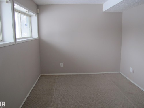 This space features neutral-toned walls, carpeted flooring, and a window providing natural light - 3617 43A Avenue, Edmonton, AB - Indoor Photo Showing Other Room