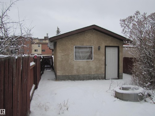 The property features a detached structure with a white door and a window, situated in a fenced yard - 3617 43A Avenue, Edmonton, AB - Outdoor
