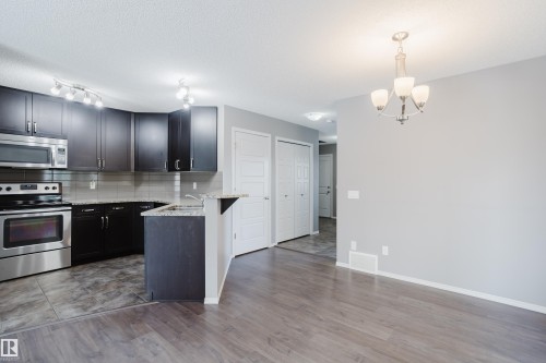 The property features a kitchen with dark cabinetry, stainless steel appliances, and granite countertops - 14007 164 Avenue, Edmonton, AB - Indoor Photo Showing Kitchen With Upgraded Kitchen