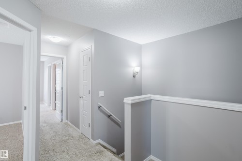 The property features a hallway with light gray walls, white trim, and light-colored carpeting - 14007 164 Avenue, Edmonton, AB - Indoor Photo Showing Other Room