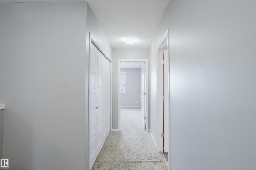 Hallway featuring light-colored walls, carpeted flooring, and a closet with white bi-fold doors - 14007 164 Avenue, Edmonton, AB - Indoor Photo Showing Other Room