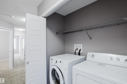 Dedicated laundry area with a washer and dryer, featuring a wire shelf for storage and a neutral paint color - 14007 164 Avenue, Edmonton, AB - Indoor Photo Showing Laundry Room