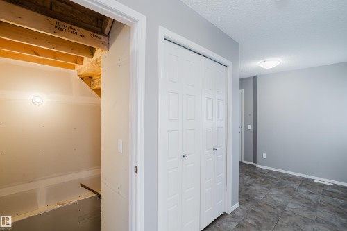 Interior space featuring ceramic tile flooring, neutral grey painted walls, and white bi-fold doors - 14007 164 Avenue, Edmonton, AB - Indoor Photo Showing Other Room