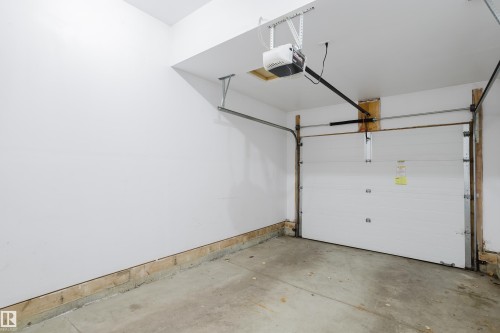 The property features a garage with a concrete floor, a white overhead door, and a garage door opener - 14007 164 Avenue, Edmonton, AB - Indoor Photo Showing Garage