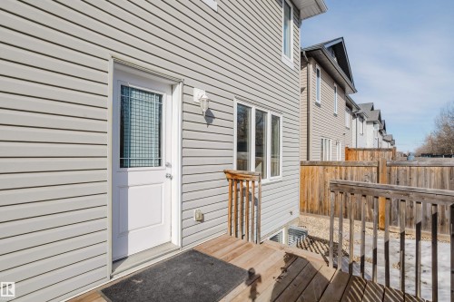 The property features a private wooden deck, a white door with a window, and light-colored siding - 14007 164 Avenue, Edmonton, AB - Outdoor With Exterior