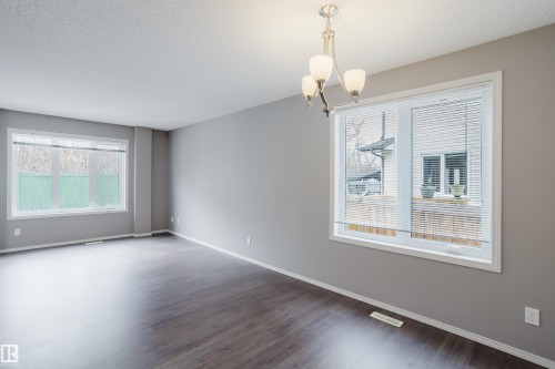 This spacious room features hard surface flooring, light grey walls, and white trim - 14009 164 Avenue, Edmonton, AB - Indoor Photo Showing Other Room