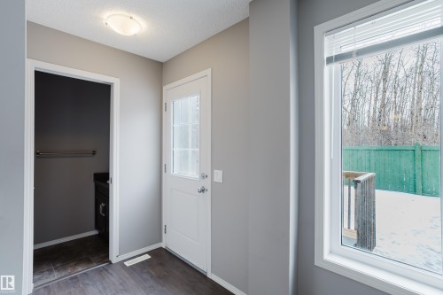 Entryway featuring dark wood flooring, a white door with glass panels, and a window overlooking a deck and fenced yard - 14009 164 Avenue, Edmonton, AB - Indoor Photo Showing Other Room