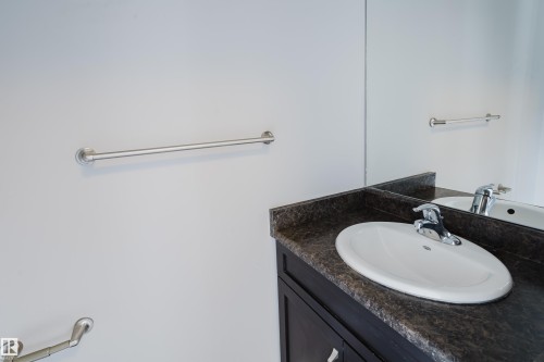 Bathroom vanity with dark countertop and white oval sink - 14009 164 Avenue, Edmonton, AB - Indoor Photo Showing Bathroom